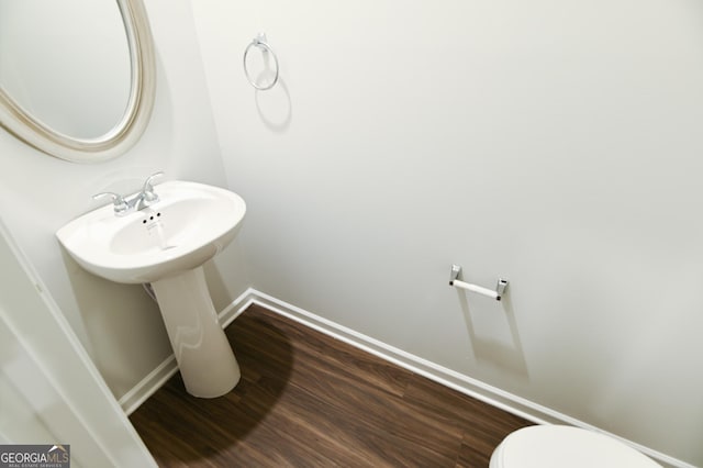 bathroom with toilet and hardwood / wood-style flooring