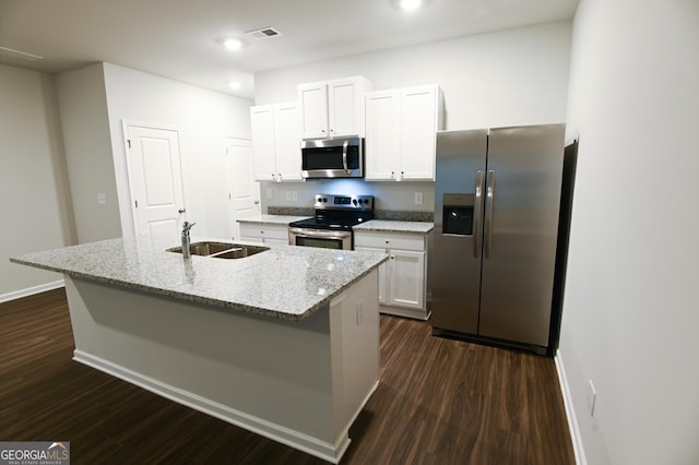 kitchen with appliances with stainless steel finishes, an island with sink, dark wood-type flooring, white cabinets, and sink