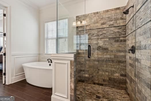 bathroom with independent shower and bath and ornamental molding