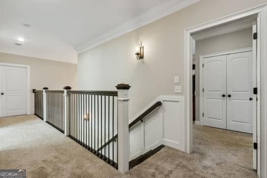 hallway featuring light colored carpet and crown molding