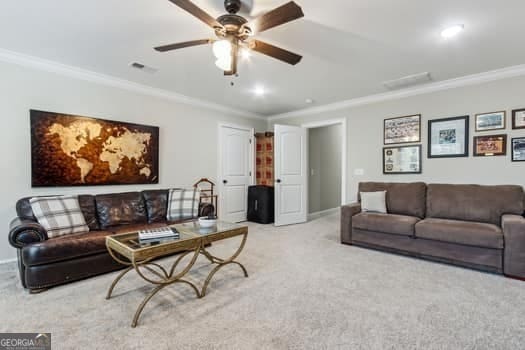 living room featuring ceiling fan, crown molding, and light carpet