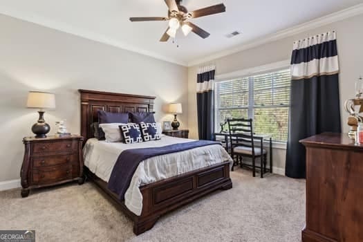 carpeted bedroom featuring ceiling fan and crown molding