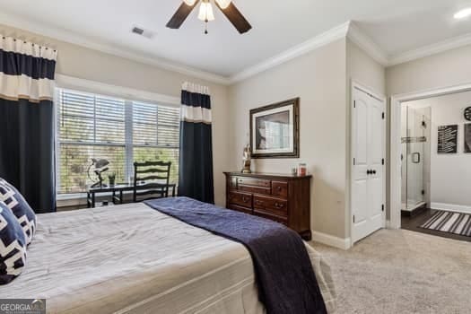 bedroom featuring ornamental molding, ceiling fan, and carpet