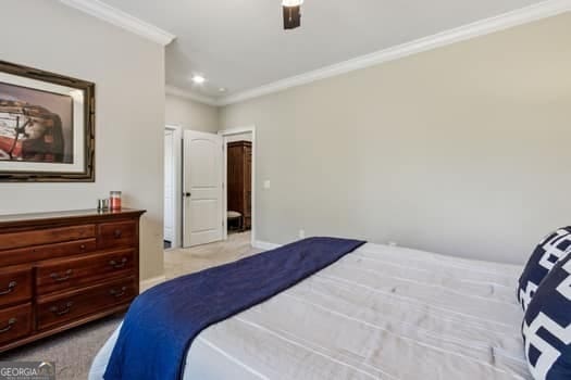 bedroom featuring ceiling fan, light colored carpet, and crown molding