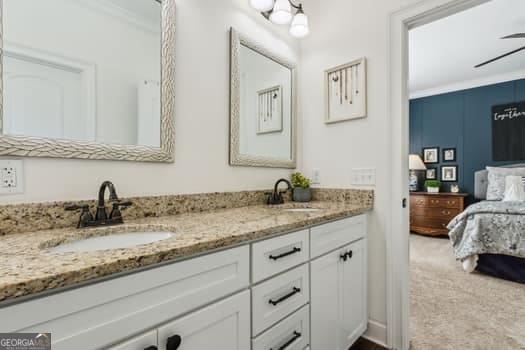 bathroom with ceiling fan, ornamental molding, and vanity