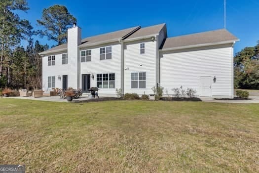 back of property featuring a yard and a patio area