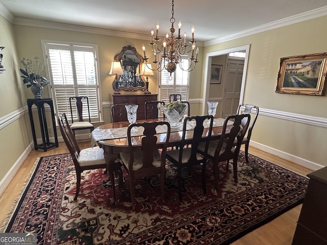 dining room with an inviting chandelier, plenty of natural light, crown molding, and hardwood / wood-style floors