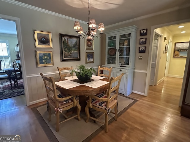 dining space with a chandelier, light hardwood / wood-style floors, and ornamental molding