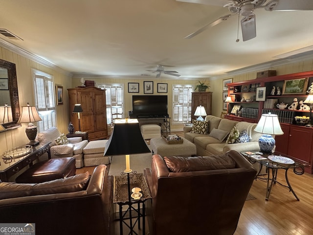 living room with light wood-type flooring, a wealth of natural light, and crown molding