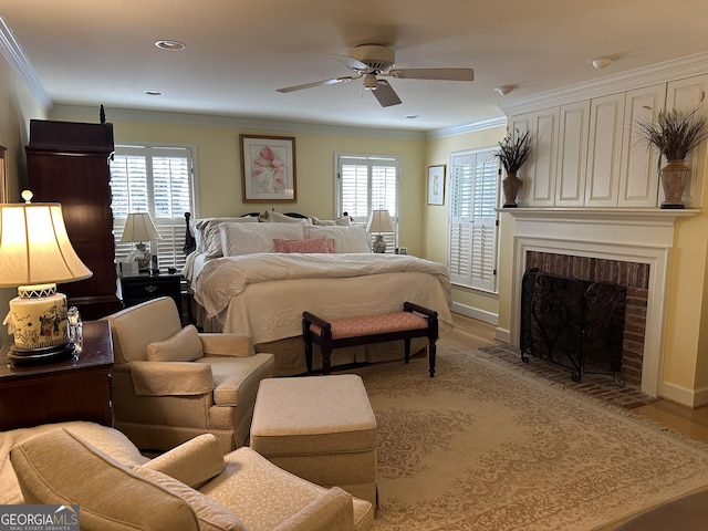 bedroom with light hardwood / wood-style floors, ornamental molding, a brick fireplace, and ceiling fan