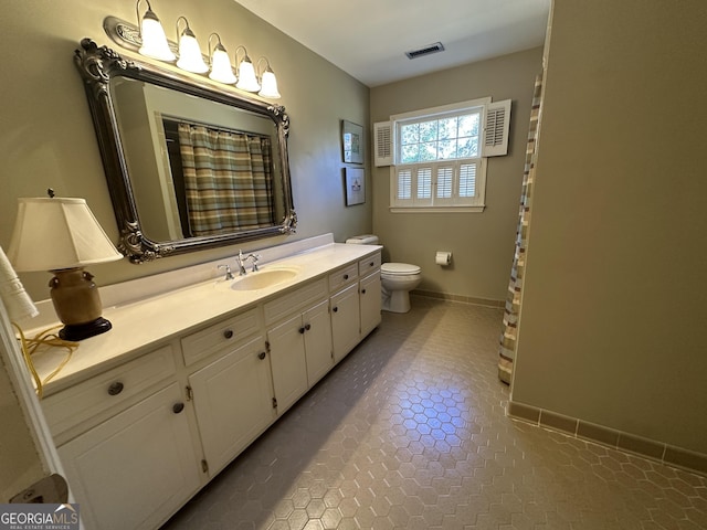 bathroom featuring toilet, tile patterned flooring, and vanity