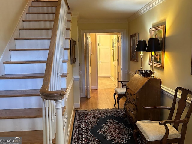 stairs with crown molding and hardwood / wood-style floors