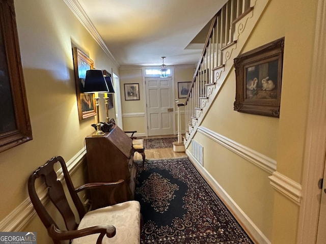 foyer entrance with wood-type flooring and ornamental molding