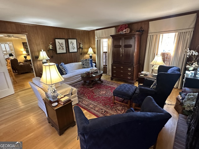 living room with a healthy amount of sunlight, light hardwood / wood-style floors, and wooden walls