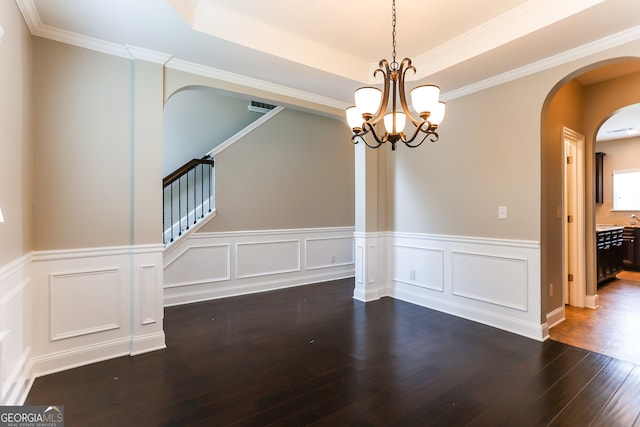 unfurnished dining area with dark wood-type flooring, a notable chandelier, crown molding, and a tray ceiling