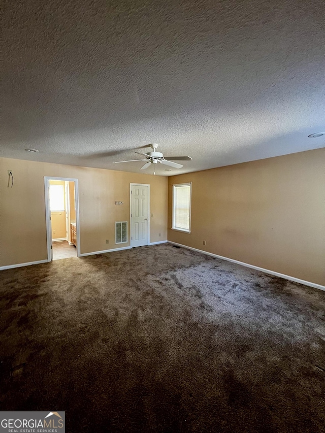 spare room with a healthy amount of sunlight, ceiling fan, carpet floors, and a textured ceiling