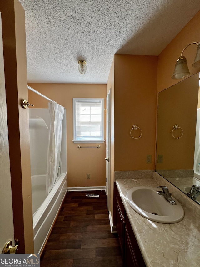 bathroom with vanity, a textured ceiling, hardwood / wood-style floors, and shower / tub combo with curtain