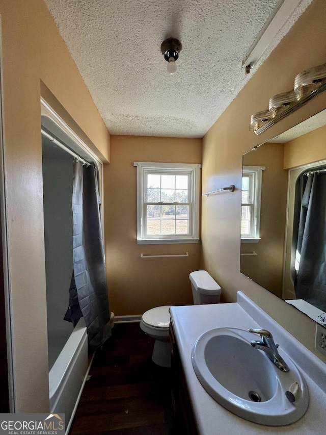 full bathroom with toilet, a textured ceiling, hardwood / wood-style floors, shower / bath combo, and vanity