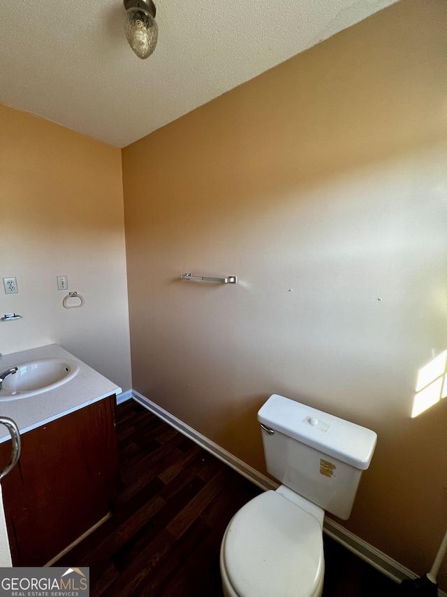 bathroom featuring toilet, vanity, and hardwood / wood-style floors