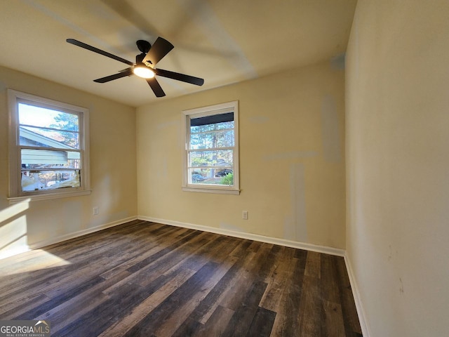 empty room featuring plenty of natural light, dark hardwood / wood-style floors, and ceiling fan