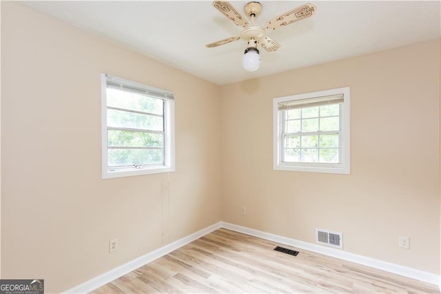 empty room with ceiling fan and light hardwood / wood-style flooring