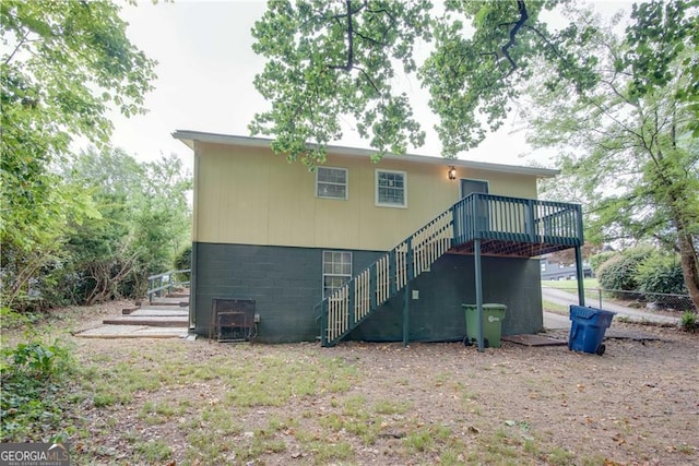 rear view of house featuring a wooden deck