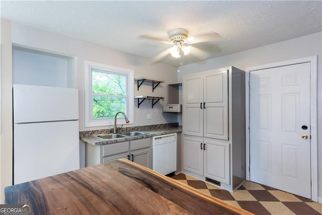 kitchen with sink, a textured ceiling, white appliances, ceiling fan, and gray cabinetry