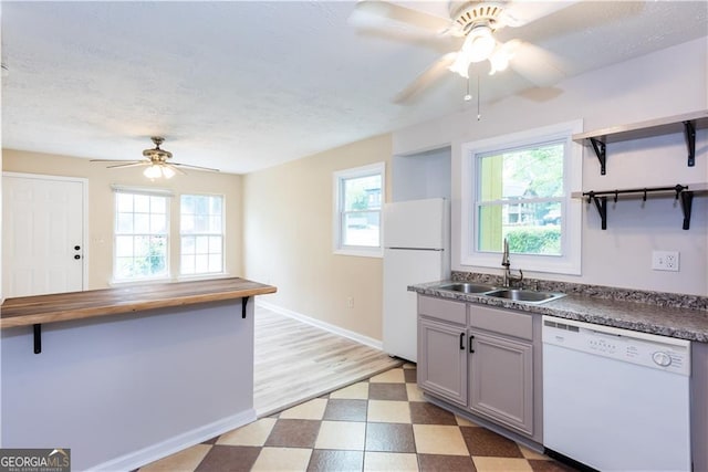 kitchen featuring sink, white appliances, a healthy amount of sunlight, and gray cabinets