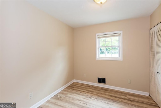 unfurnished bedroom featuring light hardwood / wood-style floors and a closet