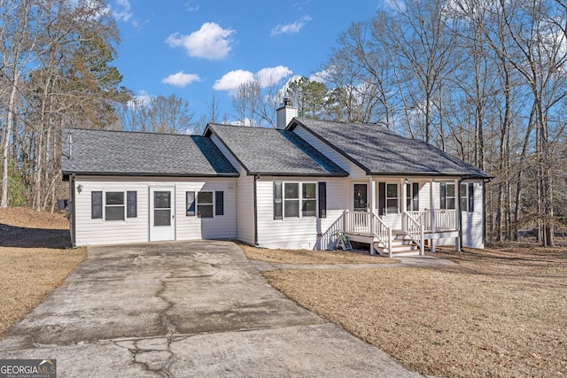 ranch-style home featuring covered porch and a front yard