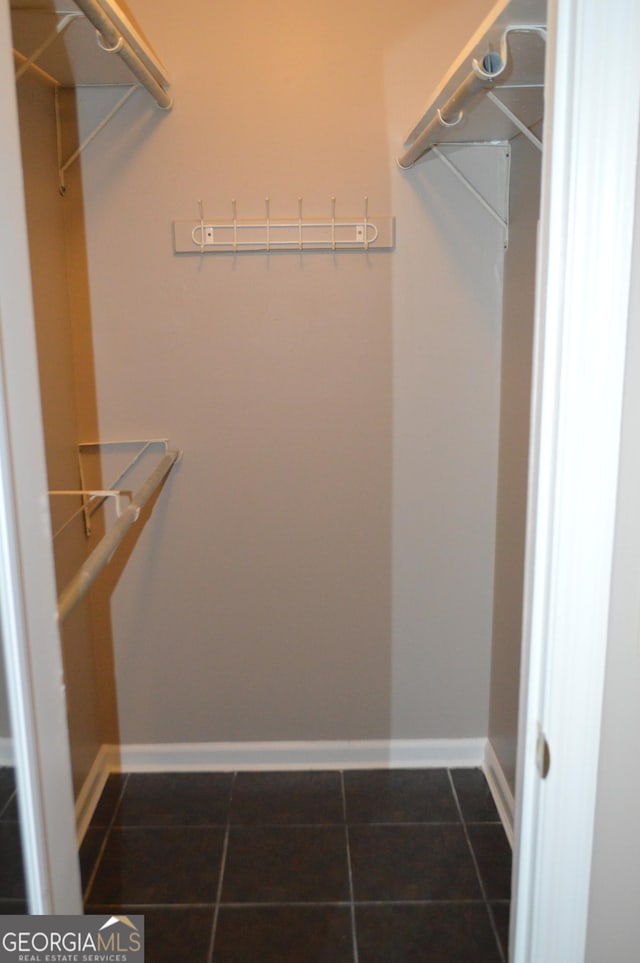 spacious closet featuring dark tile patterned flooring