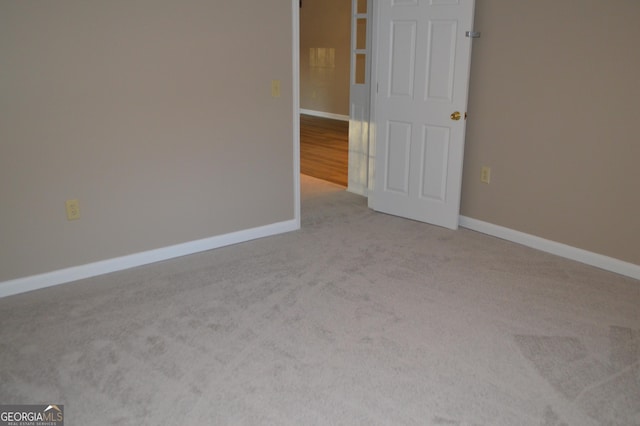 carpeted spare room featuring baseboards