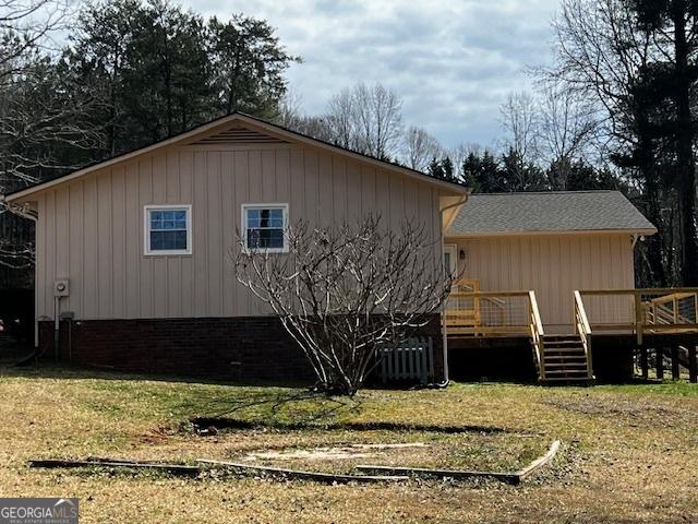 view of side of home with a lawn and a deck