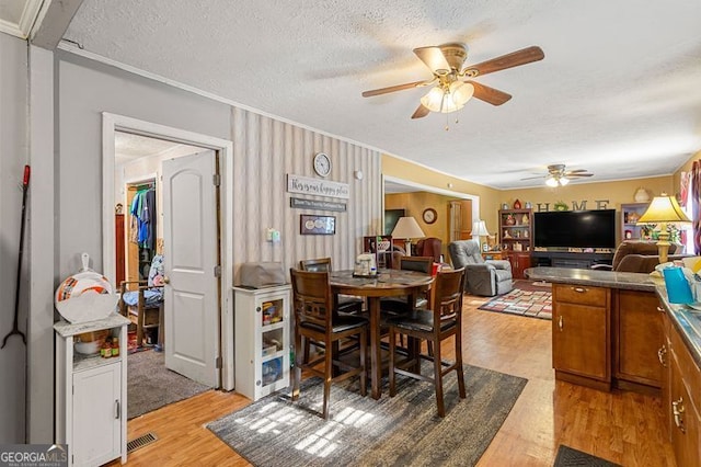 dining area featuring ceiling fan, a textured ceiling, and light hardwood / wood-style floors