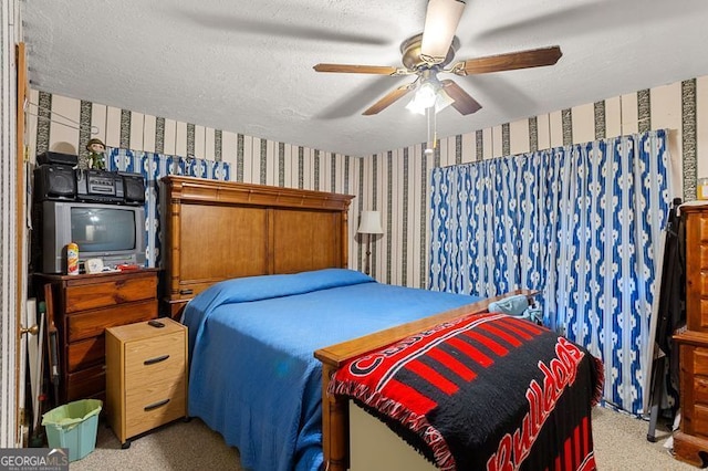 bedroom with a textured ceiling, light colored carpet, and ceiling fan