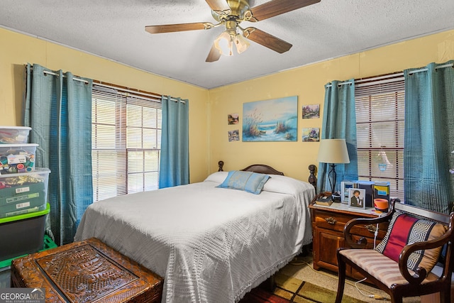 carpeted bedroom featuring a textured ceiling and ceiling fan