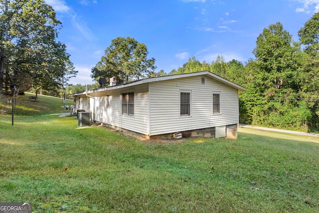 view of property exterior with a yard and central AC unit