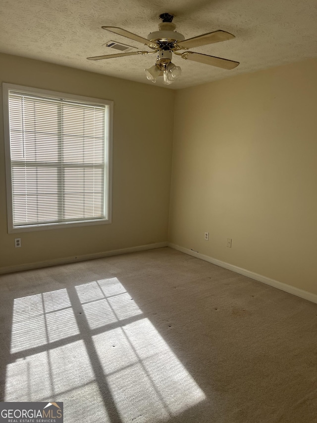 spare room with a textured ceiling and light colored carpet