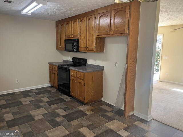 kitchen with a textured ceiling, black appliances, and dark carpet