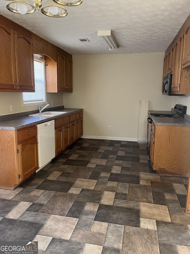 kitchen with white dishwasher, a textured ceiling, stove, and sink