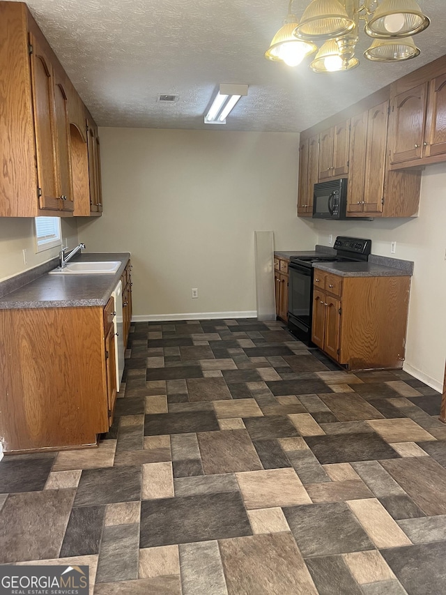 kitchen with a textured ceiling, black appliances, and sink