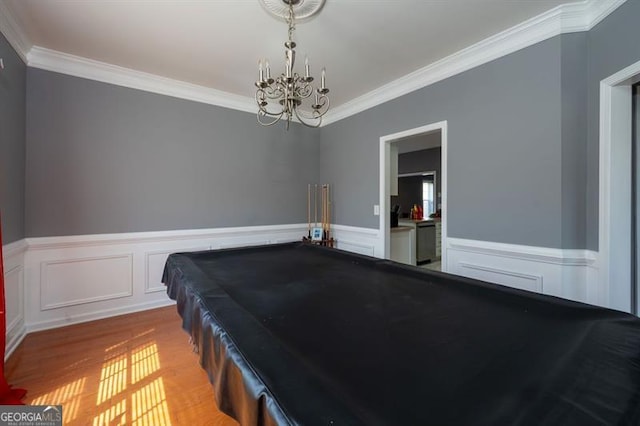 playroom with ornamental molding, light hardwood / wood-style flooring, billiards, and a notable chandelier