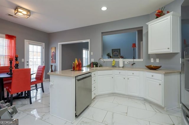 kitchen featuring kitchen peninsula, white cabinets, stainless steel dishwasher, and sink