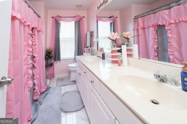 bathroom featuring tile patterned floors, vanity, and toilet