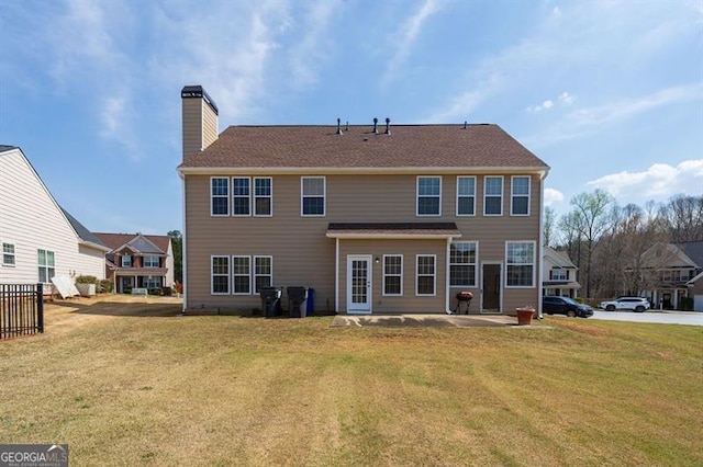 back of house featuring a patio and a lawn