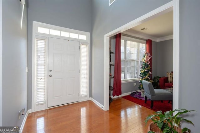 entrance foyer featuring light hardwood / wood-style floors and crown molding