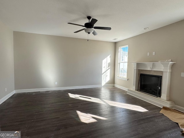 unfurnished living room with a tile fireplace, ceiling fan, and dark hardwood / wood-style floors