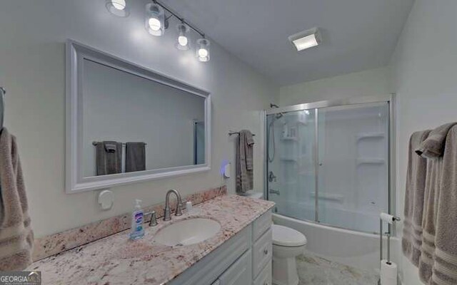 full bathroom featuring toilet, vanity, and enclosed tub / shower combo