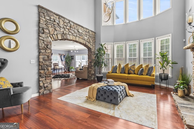 living room featuring a high ceiling, a chandelier, and dark hardwood / wood-style floors