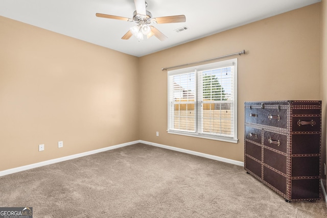 carpeted spare room featuring ceiling fan